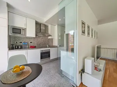 a kitchen with a table with a bowl of fruit on it at BarcelonaForRent Vila Olimpica Pool Suites in Barcelona