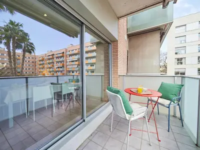 a balcony with a red table and chairs at BarcelonaForRent Vila Olimpica Pool Suites in Barcelona