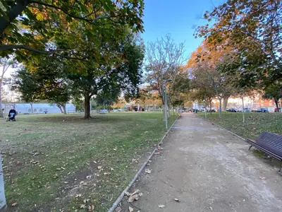 a park with a bench and trees and a path at Ponent - Espectaculares vistas al mar in San Pol de Mar