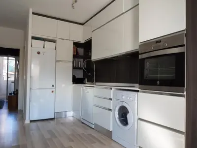 a white kitchen with a washer and dryer at Penthouse Sitges in Sitges