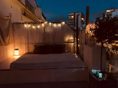 a bed on a balcony with lights on a fence at Penthouse Sitges in Sitges