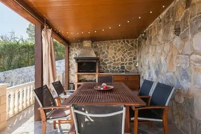 a table and chairs on a patio with a fireplace at Casa Lourdes in Canyelles