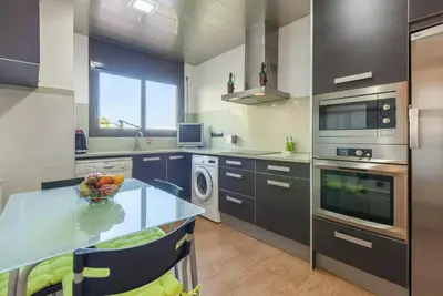 a kitchen with a table with a bowl of fruit on it at Casa Lourdes in Canyelles
