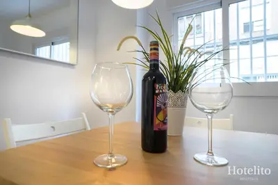 a bottle of wine sitting on a table with two glasses at Hotelito Boutique Cinca in Hospitalet de Llobregat