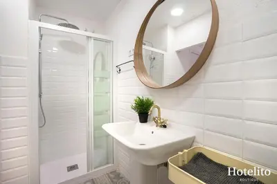 a white bathroom with a sink and a mirror at Hotelito Boutique Cinca in Hospitalet de Llobregat
