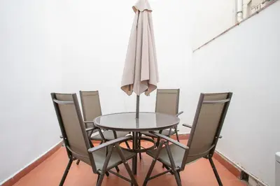 a dining room table with chairs and an umbrella at Alcam Alio 2 in Barcelona