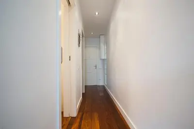 a hallway with a white wall and wooden floors at Tendency Rambla del Poblenou in Barcelona