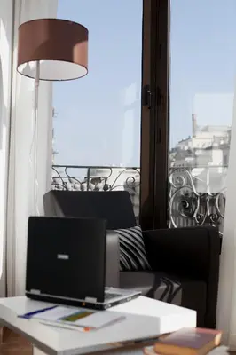a laptop computer sitting on a table in front of a window at Serennia Apartamentos Ramblas - Plaça Catalunya in Barcelona