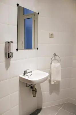 a white bathroom with a sink and a mirror at Alguera Apartments Napols in Barcelona