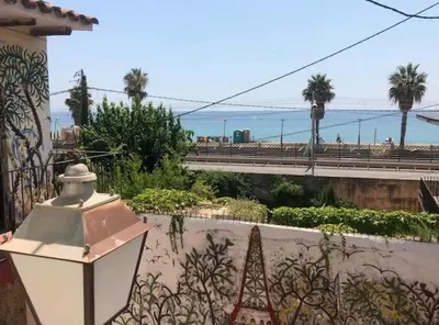 a street light next to a wall with a view of the ocean at The Painter's Home in Vilassar de Mar