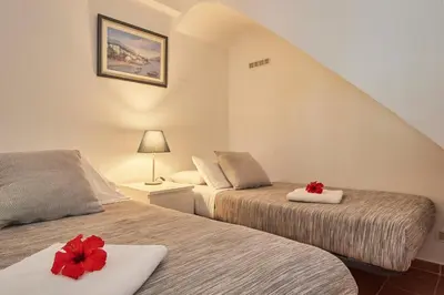 a bedroom with two beds with red flowers on them at ARTS HOUSE - Cabrils, Maresme, Barcelona in Cabrils