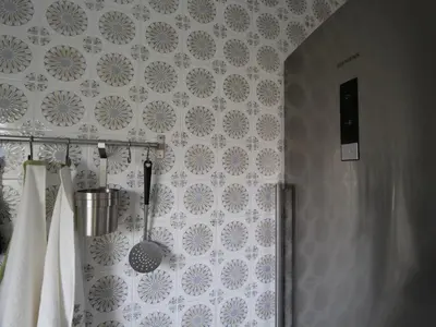 a bathroom with blue and white wallpaper and white towels at Apartamento Maraka Playa Castelldefels in Castelldefels
