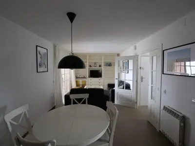 a white table and chairs in a living room at Apartamento Maraka Playa Castelldefels in Castelldefels