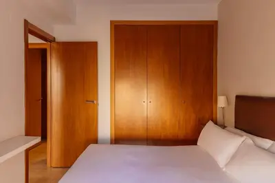 a bedroom with a white bed and a television at Barcelona Apartment Gran de Gràcia in Barcelona