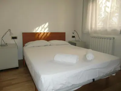 a bedroom with a white bed with two towels on it at Apartamentos City Beach in Barcelona