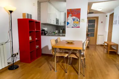 a kitchen and dining room with a table and a red cabinet at Apartamentos City Beach in Barcelona