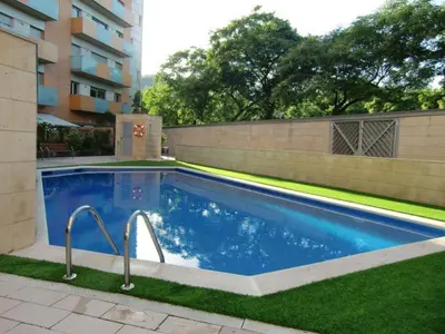 a swimming pool in a yard next to a building at Apartamentos City Beach in Barcelona