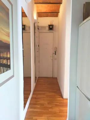 a hallway with a white door and a wooden floor at Barceloneta Port Ramblas in Barcelona