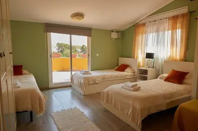a bedroom with two beds and a large window at Amazing Vila close to Sitges, jacuzzi, swimming pool & exellent views in Olivella