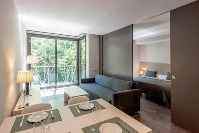 a living room with a couch and a room with a bed at Espais Blaus Apartments in Barcelona