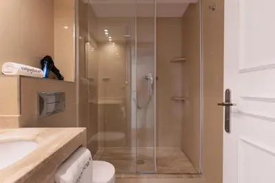 a bathroom with a shower with a toilet and a sink at Enjoybcn Dali Apartments in Barcelona