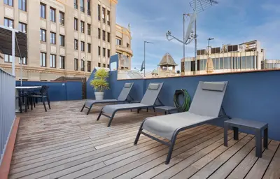 a balcony with chairs and a table on a building at Enjoybcn Dali Apartments in Barcelona