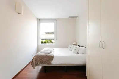 a white bedroom with a bed and a window at 4131 - AB Diagonal - Sant Adrià de Besòs in Sant Adria de Besos