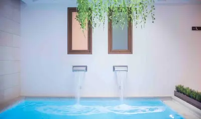 a pool with two water fountains and two windows at Sono & SPA - Adults Only in La Garriga