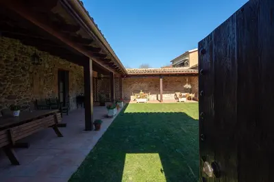 a patio with a grassy yard with a bench at Mas Can Calet Aparthotel in Les Franqueses del Vallès
