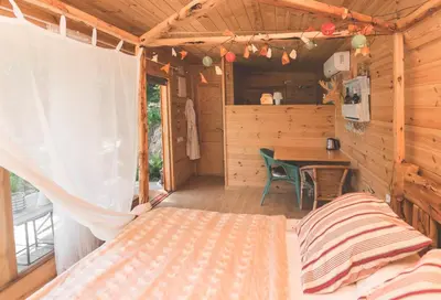 a bedroom in a log cabin with a bed and a table at Can Caponet in Lliçà d'Amunt