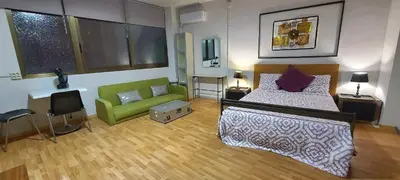 a bedroom with a bed and a green couch at Great Sleep Loft in Barcelona