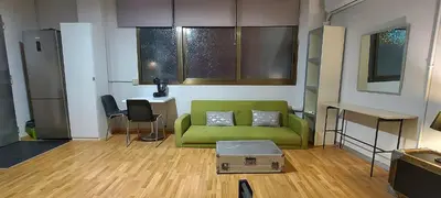 a living room with a green couch and a table at Great Sleep Loft in Barcelona