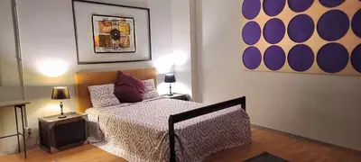 a bedroom with a bed and two tables with lamps at Great Sleep Loft in Barcelona