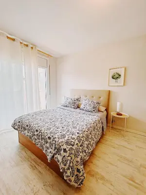 a bedroom with a bed and a window at Tropical Apartaments Euroviajeros in Pineda de Mar