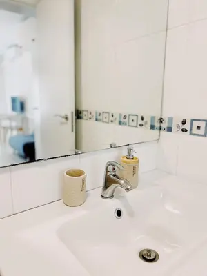 a bathroom sink with a faucet and a mirror at Tropical Apartaments Euroviajeros in Pineda de Mar