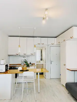 a kitchen with a wooden table and white cabinets at Tropical Apartaments Euroviajeros in Pineda de Mar