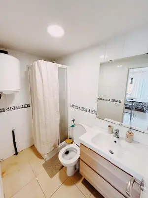 a bathroom with a toilet and a sink and a mirror at Tropical Apartaments Euroviajeros in Pineda de Mar