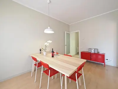 a dining room with a wooden table and red chairs at Sagrada Penthouse in Barcelona