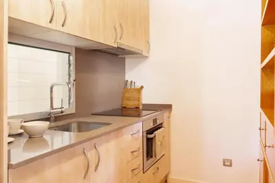 a kitchen with wooden cabinets and a sink at Dream Gracia Apartments in Barcelona