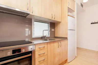 a kitchen with wooden cabinets and a sink and a window at Dream Gracia Apartments in Barcelona