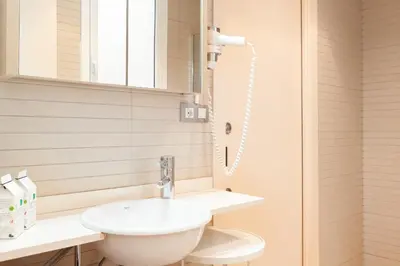 a white bathroom with a sink and a mirror at Dream Gracia Apartments in Barcelona