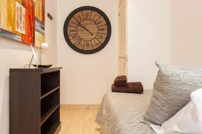 a bedroom with a clock on the wall next to a bed at Dream Gracia Apartments in Barcelona