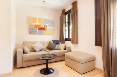 a living room with a couch and a stool at Dream Gracia Apartments in Barcelona