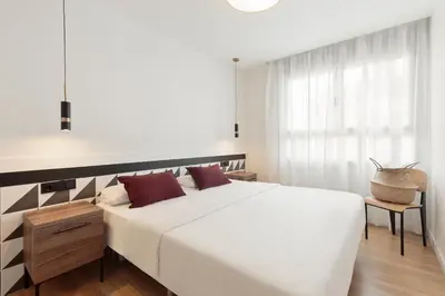 a bedroom with a large white bed and a window at Port Forum Apartments by Olala Homes in Sant Adria de Besos