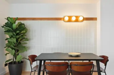 a dining room table with chairs and a plant at Port Forum Apartments by Olala Homes in Sant Adria de Besos
