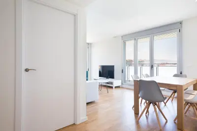 a white dining room with a table and chairs at Port Forum Apartments by Olala Homes in Sant Adria de Besos