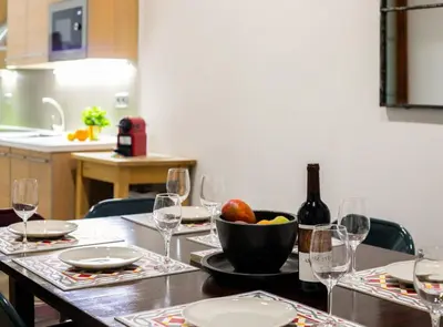 a table with a bowl of fruit and a bottle of wine at GREAT SPACIOUS APARTMENT IN THE GOTHIC QUARTER in Barcelona