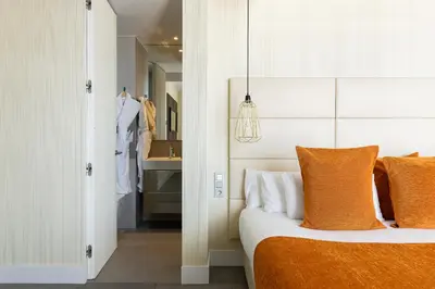 a bedroom with a bed with orange and white pillows at Cosmo Suite Penthouse in Barcelona