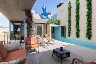 a patio with chairs and plants on a building at Cosmo Suite Penthouse in Barcelona