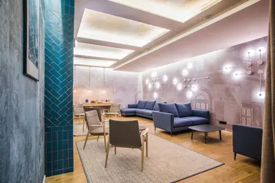 a living room with blue couches and a table at Sleep&Fly in El Prat de Llobregat